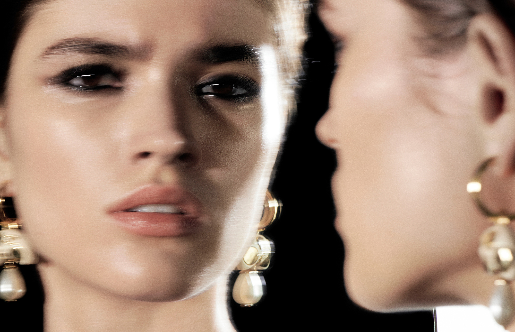 Frauengesicht im Spiegel mit Perlenohrringen