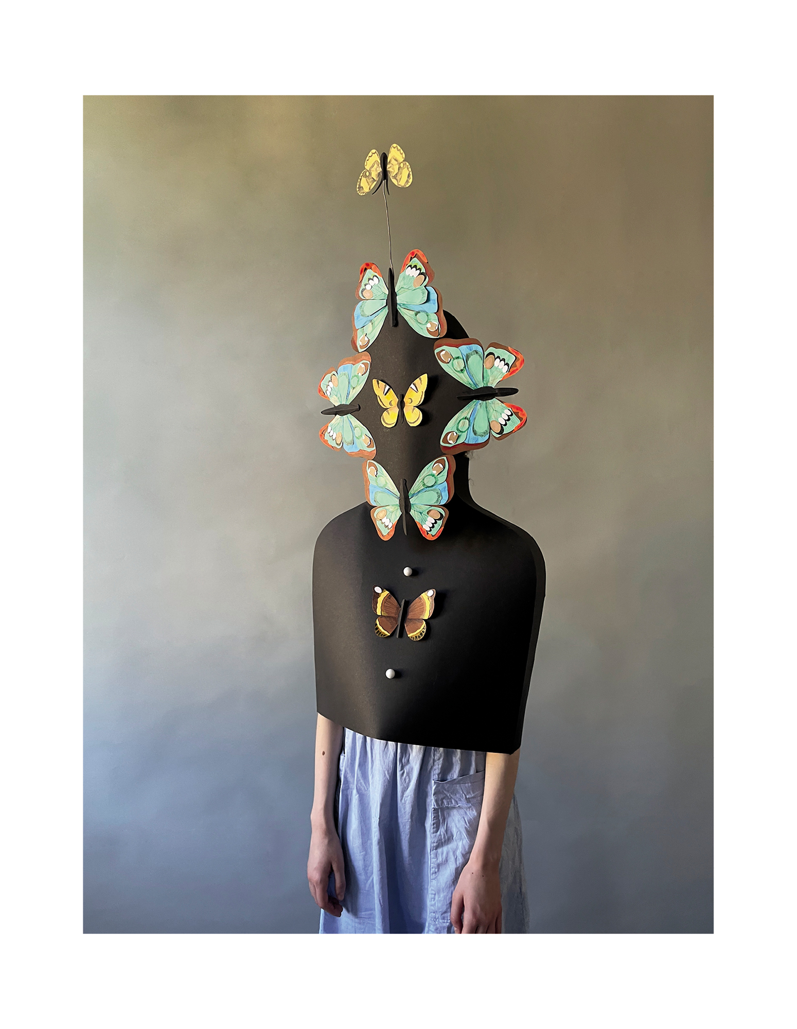 Model in Maske, die das gesicht mit Schmetterlingen verdeckt