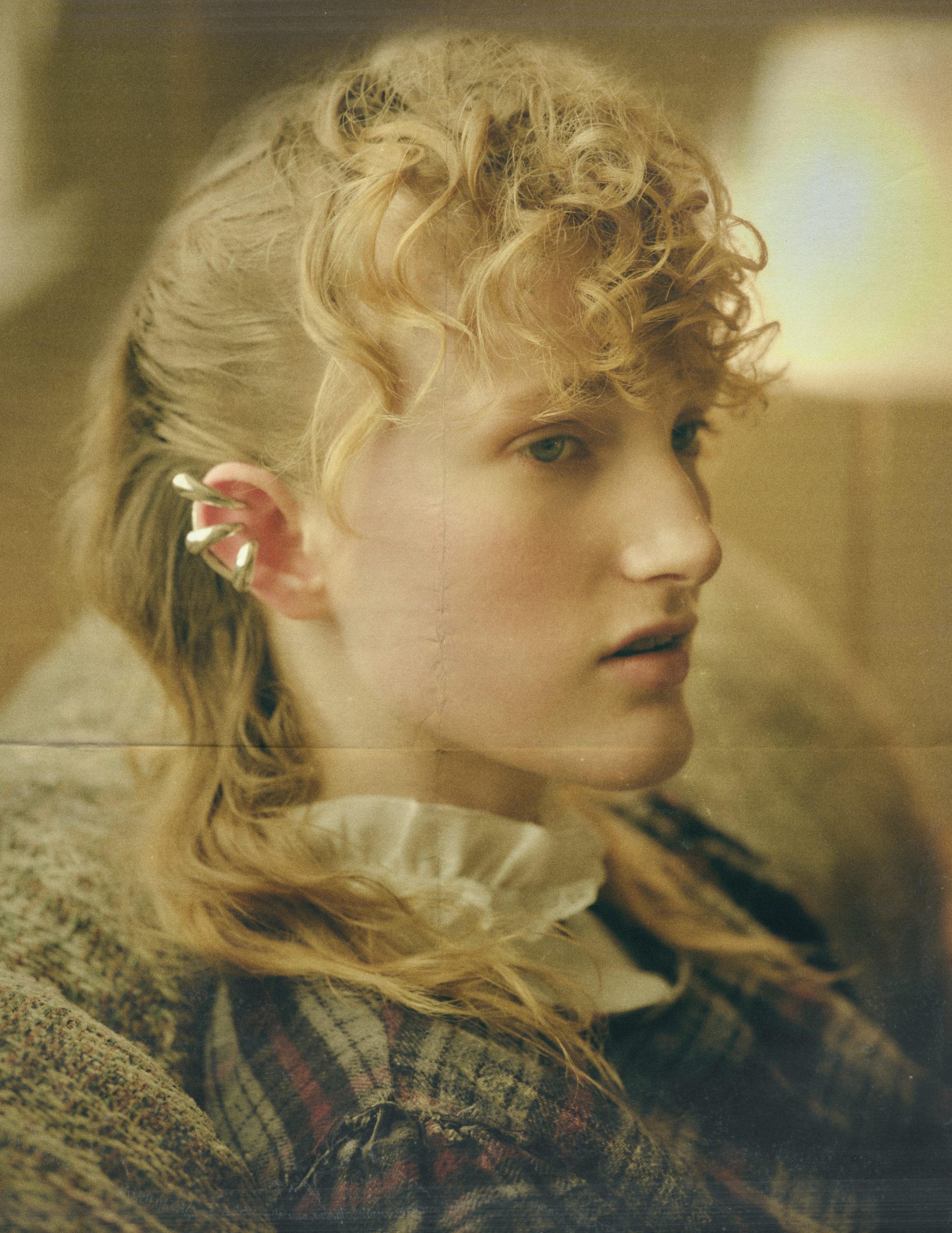 woman with blonde curly hair and silver earcuffs