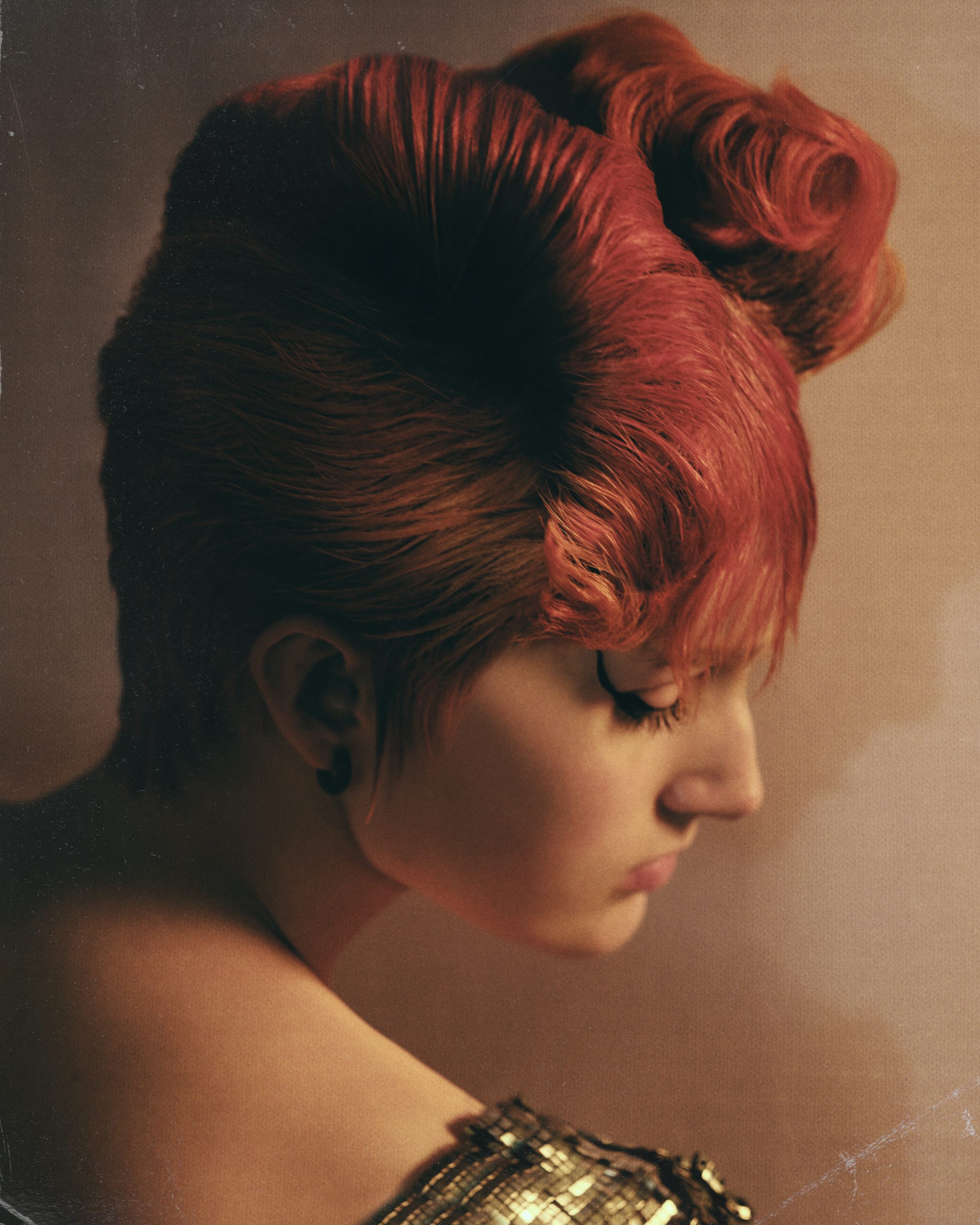 woman with red hair and black eyeliner in profile