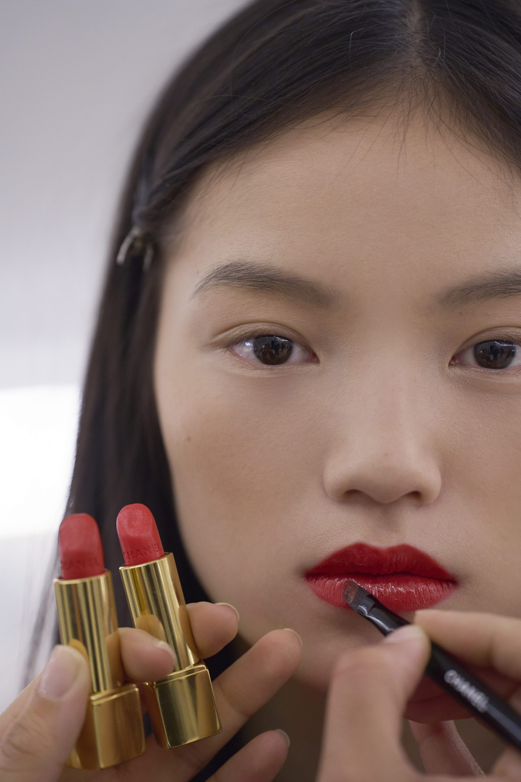 Asiatisches Model bekommt rote Lippen geschminkt