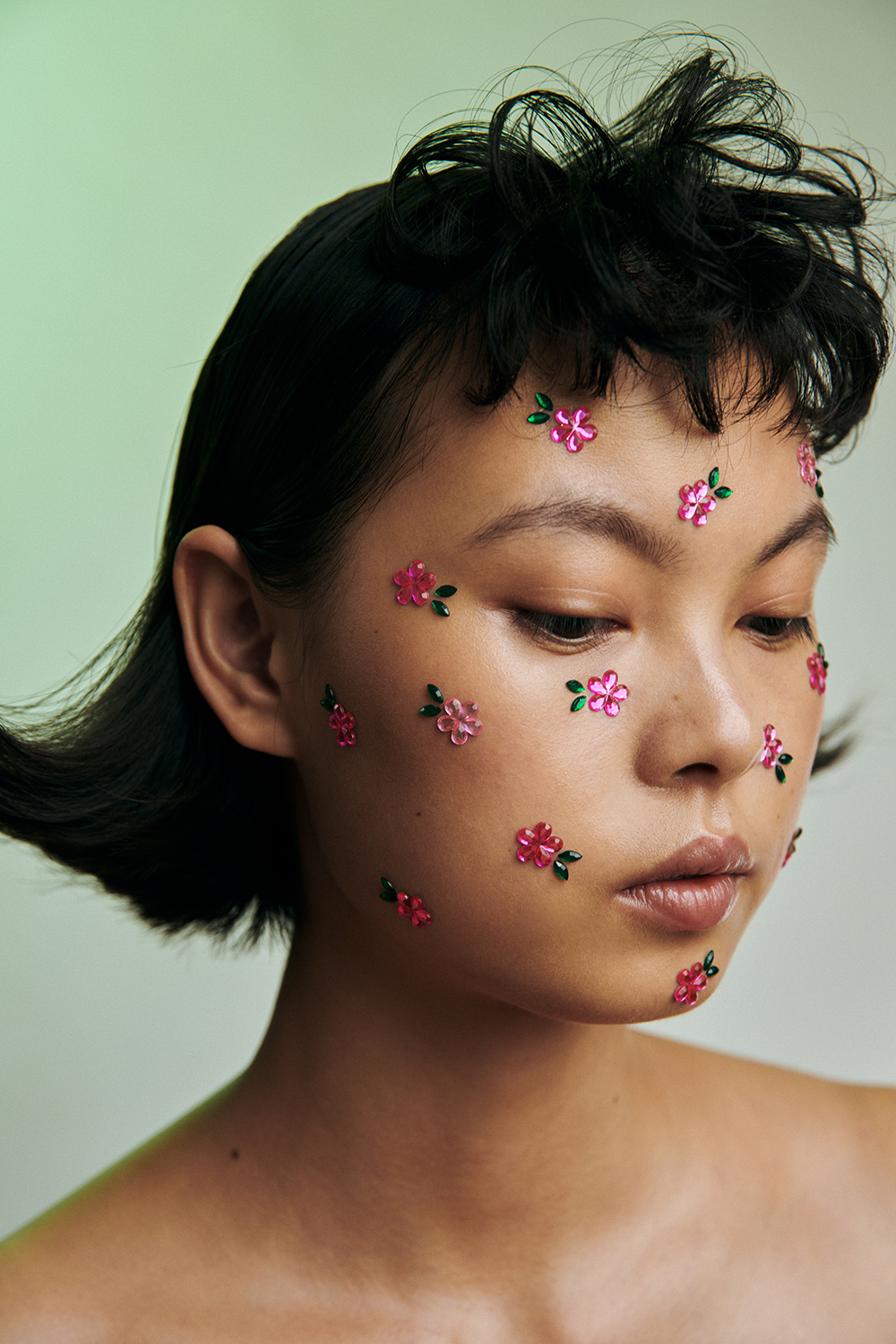 Model mit pinken Blumen im Gesicht