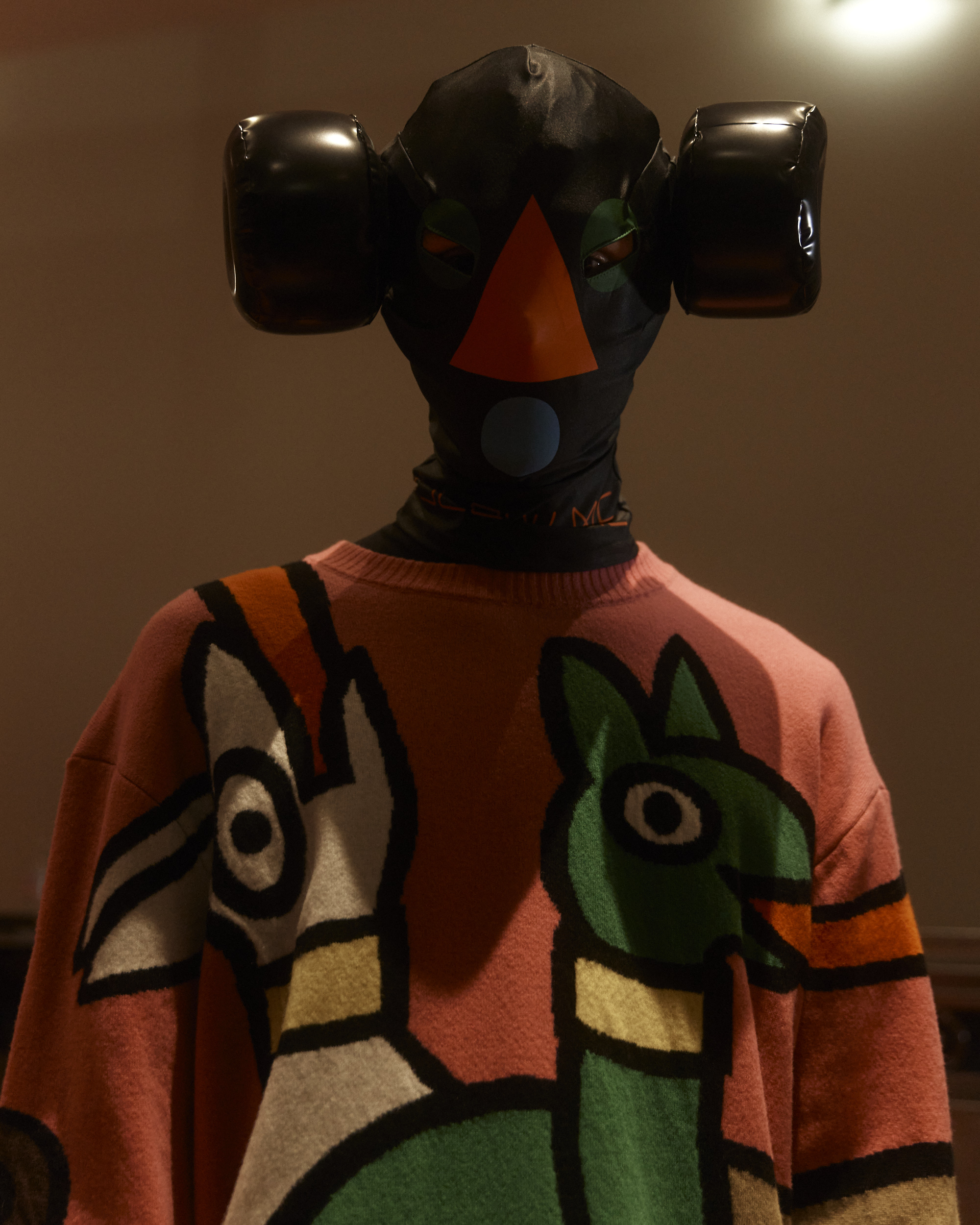 Model wearing a face mask and patterned sweater