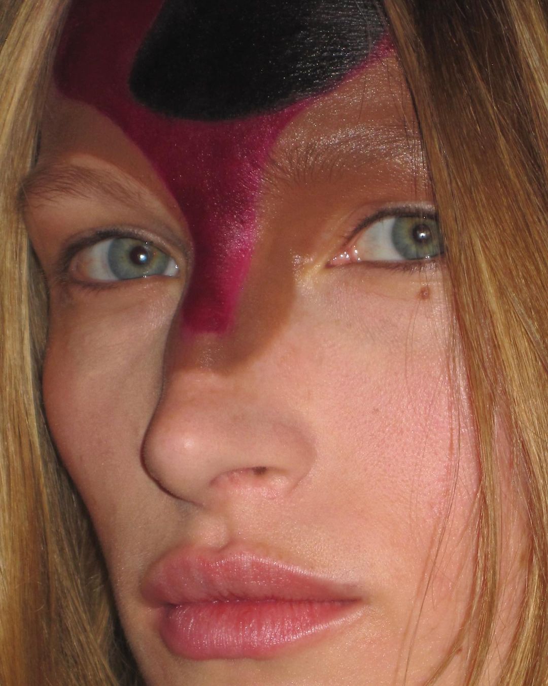 Woman with brown, pink and black colour on her forehead