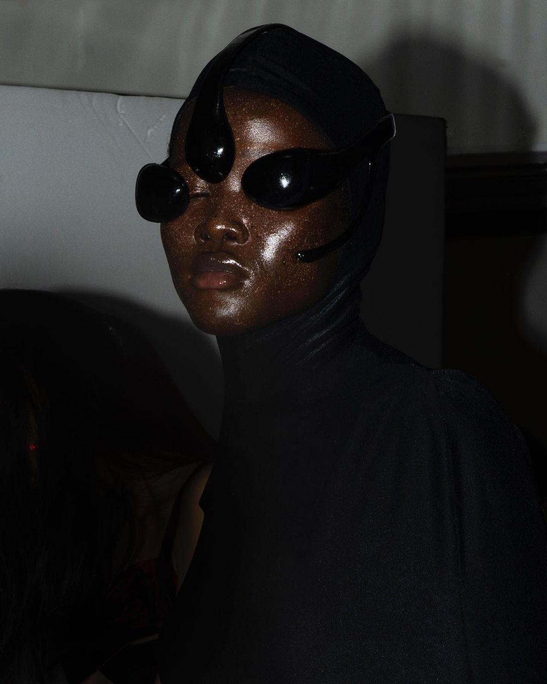 Black model, eyes covered, dark